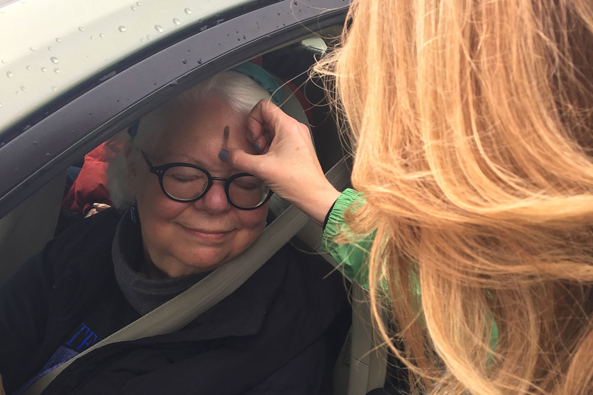 Rev. Lisa administering ashes to a woman in her car